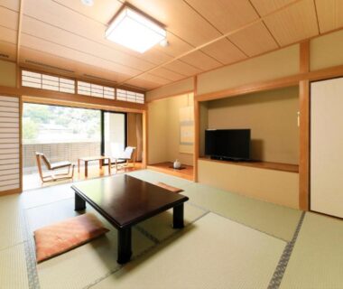Traditional tatami room with low table, shoji screens, balcony seating and greenery view at La Conte Arima Hyogo