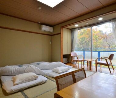 Tatami room with futons at Matsutake Sansō, Nagano Chūbu Japan, trees outside the window
