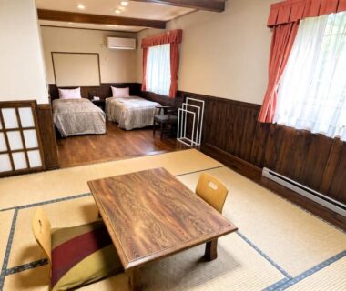 Tatami room with low wooden table and twin beds at Morinouta, Nikko, Tochigi