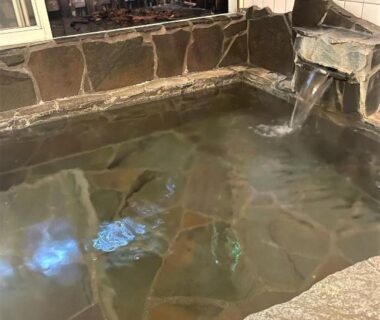 Stone onsen bath with flowing spout at Morinouta Forest Stay, Nikko, Tochigi Japan