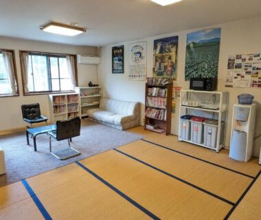 Tatami lounge with low table, sofa, bookshelves and kitchenette at Kitakaruizawa Kogen Hotel in Gunma Kanto