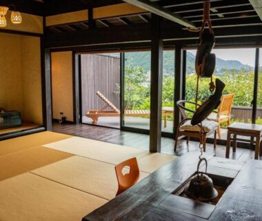 Traditional tatami room with irori hearth, shoji screens and veranda overlooking wooded hills at Musōan Biwa, Shizuoka