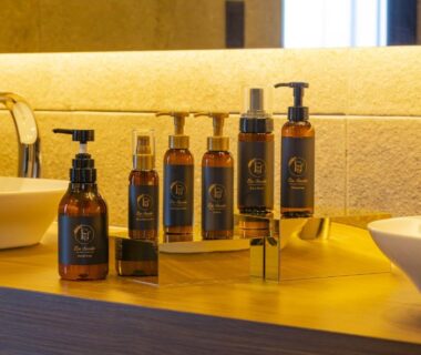 Amber toiletry bottles on wooden vanity with twin vessel sinks at Musōan Biwa, Shizuoka