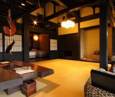 Spacious tatami room with low wooden table, shoji screens, exposed beams and seating area