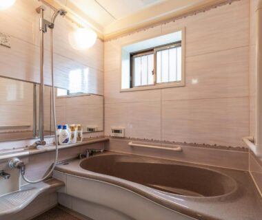 Tiled bathroom with soaking tub, hand shower, toiletries and window at 楽心館Yufuin in Ōita