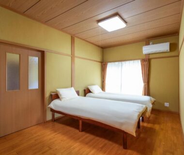 Two single beds on wooden floor in Rakushinkan room, Yufuin Ōita