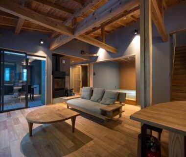 Indoor wooden lounge with low sofa, coffee table and staircase at Yudono Totonoyu, Yokokawa Onsen, Shizuoka