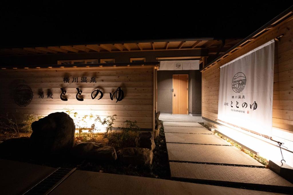 Illuminated entrance Yudono Totonoyu Yokokawa Onsen Warm lit wooden entrance with stone path and noren curtain at Yudono Totonoyu, Yokokawa Onsen, Shizuoka
