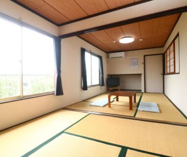 Tatami room with low table and floor cushions at Minshuku Kazu in Chiba Kanto