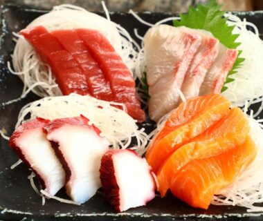 Assorted sashimi with shredded daikon and shiso on black plate at Minshuku Kazu, Chiba, Kantō