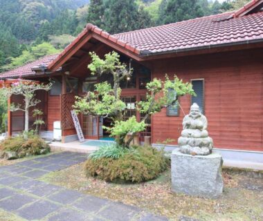 Entrance pathway, shrubbery and stone statue at Minshuku Hiroshige in Ōita, Kyūshū