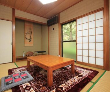 Tatami room with low table, zabuton cushions and shoji screens at Minshuku Hiroshige in Oita, Kyushu