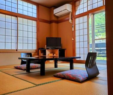 Tatami room with low table, zabuton cushions and shoji at Atasawaya Ryokkan in Tokyo, Japan