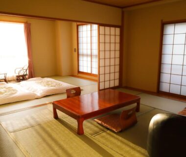 Tatami room with futon, low table and shoji screens at Ichinose, Shizuoka