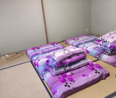 Tatami room with purple floral futons on tatami mats at Amakawa Ryokan in Kawazu, Shizuoka