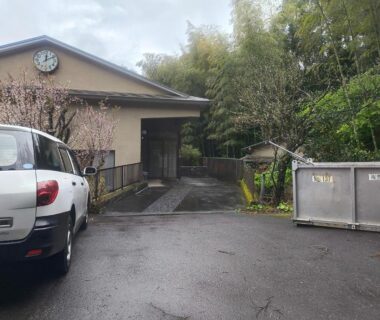 Front driveway and parking area leading to ryokan entrance with bamboo and clock, Kawazu Shizuoka