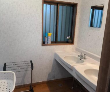 Double sink vanity with wooden floor and drying rack at Amakawa Ryokan Kawazu, Shizuoka