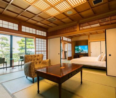 Japanese tatami room with low table, bed, shoji screens and garden view at Senshin Waho in Hyōgo