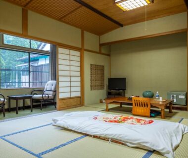Traditional tatami room with futon, low table, shoji screens and garden-view veranda at Marubun Dorogawa Onsen Nara
