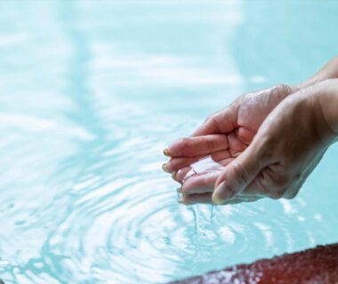 Hands skimming hot spring water at Marubun auberge thermale in Dorogawa Onsen, Nara