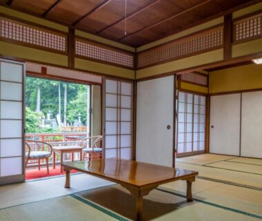 Traditional tatami room with low wooden table and shoji doors opening to a wooded veranda at Marubun in Nara