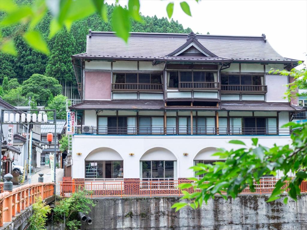 Riverside Ryokan Marubun Dorogawa Nara Three-story riverside ryokan with wooden balconies and lush hillside backdrop in Dorogawa, Nara, Kansai, Japan