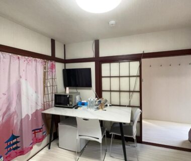 Small desk with TV, microwave and chairs in a room with shoji screens at Futago no Yado, Asakusa Tokyo