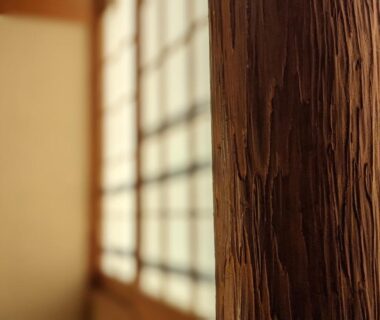 Close-up of textured wooden pillar with shoji screens in a traditional ryokan interior at Onsenya Hirosuke, Fukushima