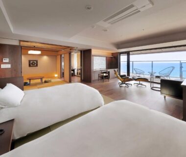 Spacious room with twin beds, tatami seating area and balcony overlooking the sea at Yūsuitei Isagoya, Yamagata