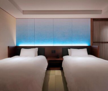 Twin beds with illuminated headboard and lattice partition at Yūsuitei Isagoya, Yamagata