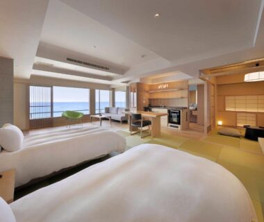 Twin beds, tatami seating area, shoji screens and large window with water view at Yūsuitei Isagoya