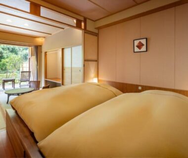 Tatami room with twin futons, shoji screens, low table and balcony overlooking greenery at Yūsen Shidate in Iwate Tōhoku Japan