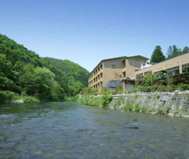 River with ryokan building and lush forested hills, Yūsen Shidate, Iwate Tōhoku