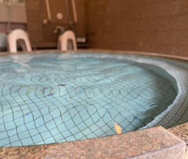 Circular tiled indoor onsen bath with stone edge at Yuyado Sasakura, Hyōgo