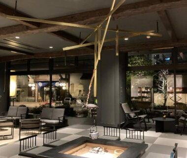Contemporary lounge with sunken hearth, low seating, wooden beams and garden view at Oyado Kotobuki, Hyōgo