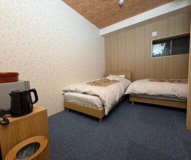 Compact twin room with two beds and kettle at Auberge de poudreuse de Yuzawa, Niigata