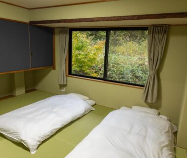 Traditional tatami room with two futons and a window overlooking greenery at Yune no Sakura, Gunma