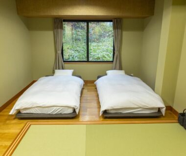 Two futons on tatami floor with window showing greenery at Yune no Sakura, Gunma, Kantō