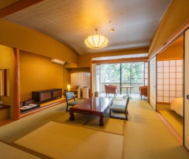 Traditional tatami room with low table, shoji screens and balcony overlooking greenery at Fukunoya in Gunma
