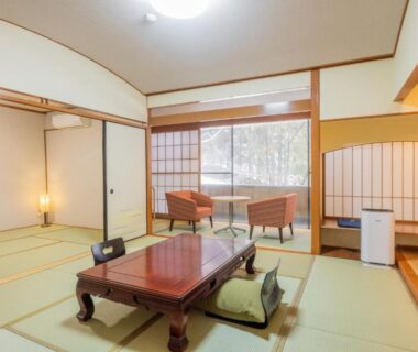 Traditional tatami room with low wooden table, zabuton cushions and shoji screens at Fukunoya, Gunma