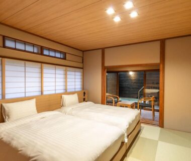 Twin beds on tatami with shoji screens and wooden bath at 源泉掛け流しの宿Albergo湳楽 in Kanagawa Kantō