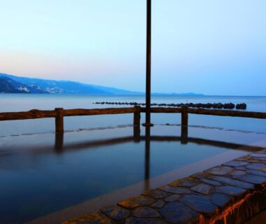 Outdoor stone onsen bath overlooking calm sea at Yunoyado Hiratsuru in Atami, Shizuoka