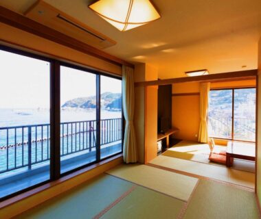 Tatami room with low table and balcony overlooking Atami coastline at Yunoyado Hiratsuru, Shizuoka