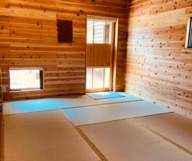 Tatami room with wooden paneled walls and low windows at ryokan 玄か~sizuka~ in Kyoto