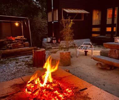 Outdoor fire pit with wooden seating in ryokan courtyard at 玄か~sizuka~ Kyoto