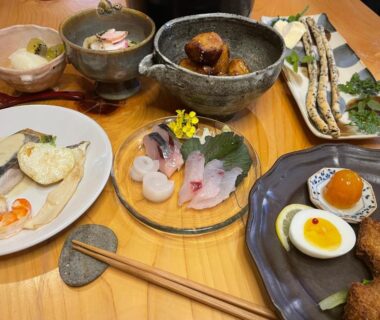 Assorted sashimi and small Japanese dishes on a wooden table at 玄か~sizuka~ Kyoto