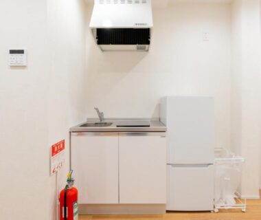 Small kitchenette with sink, stovetop, and mini fridge at Mizu no Yado Asakusa in Tokyo