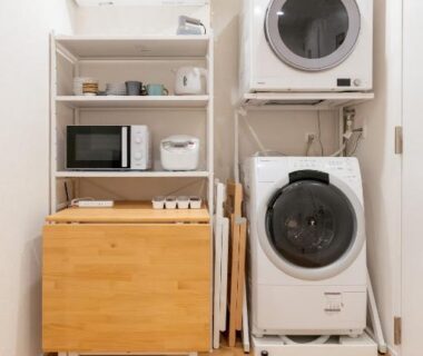 Stacked washer and dryer with shelving and kettle at Mizu no Yado Asakusa in Tokyo