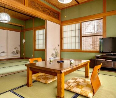 Tatami room with low table and cushions at Ryoso Makibanoie in Oita, Kyūshū, Japan