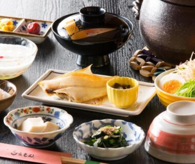 Grilled fish, miso soup, tofu and assorted side dishes on lacquer tray at a ryokan meal setting